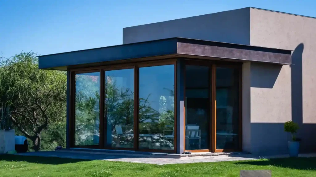 A contemporary home with large glass windows and a glass facade, illustrating different types of glass used in construction for aesthetics and insulation.